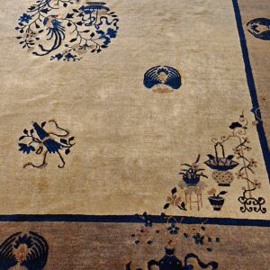 Tan field rug with ornate blue bird, flower, and vase patterns bordered in solid brown and blue.