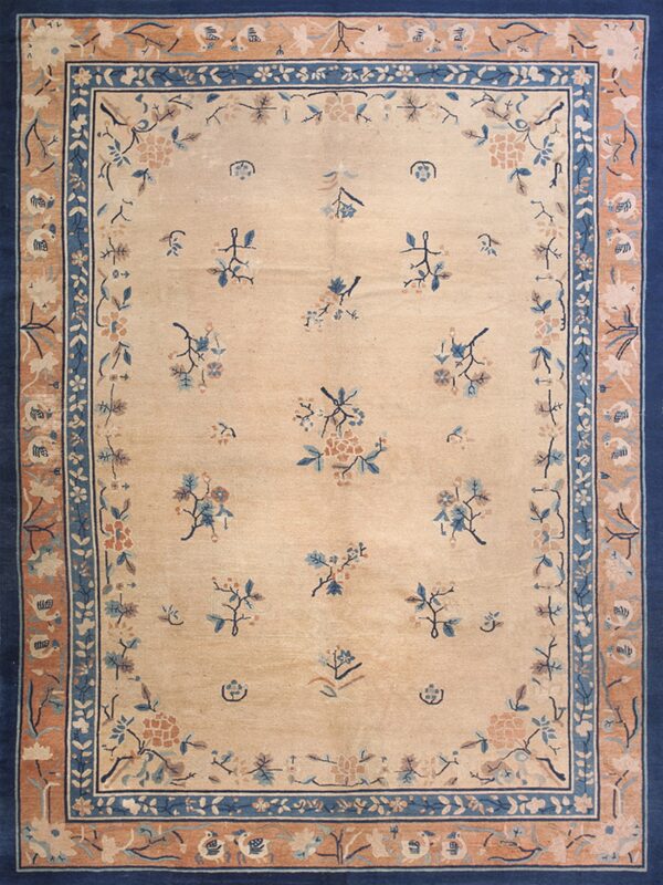 Light beige rug with scattered blue and peach floral designs framed by layered navy blue and tan borders.