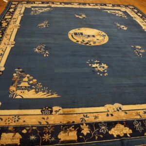 Deep blue rug with cream borders and landscape designs, including a circular central medallion, placed on hardwood.