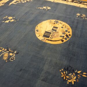 Deep blue rug with a central gold medallion, blue and yellow floral elements, bordered by cream and dark blue.