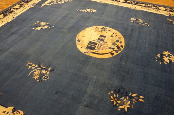 Deep blue rug with a central gold medallion, blue and yellow floral elements, bordered by cream and dark blue.