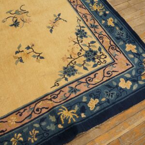 Yellow rug with blue, pink, and gold floral patterns rests on aged wooden floorboards.