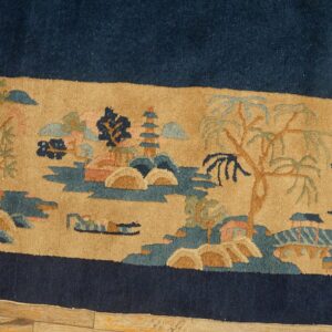 Navy blue rug field bordered by a tan landscape pattern depicting trees, pagodas, and hills.