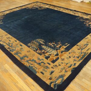 Deep blue rug with an expansive tan border featuring detailed pagodas and florals on light wood floors.