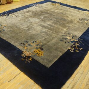 Area rug with a dark navy border and a gray field featuring gold and blue floral motifs.