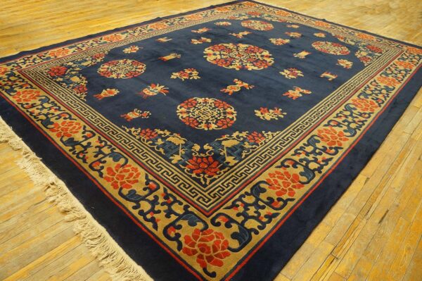 Navy blue rug featuring intricate gold and red medallions and borders on golden wood flooring.