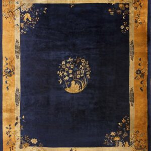A deep blue rug with a wide gold botanical border and a centered golden floral figure design.