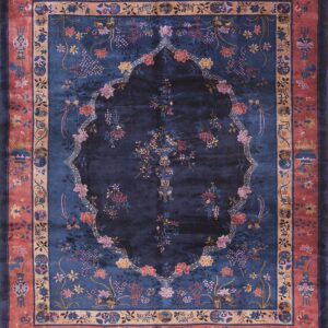 Dark blue floral rug featuring a central lobed design and a wide rose-colored border with vases.