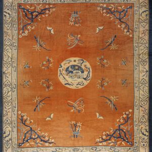 High-pile orange rug with blue and cream accents, featuring a central medallion and botanical motifs.