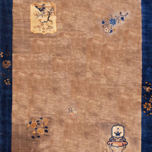 Tan rug with a wide blue border displaying gold floral vines and isolated pictorial motifs in the field.