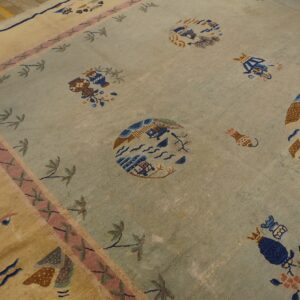 Light blue rug features scattered scenic designs and a wide border with pink and tan accents on wood flooring.