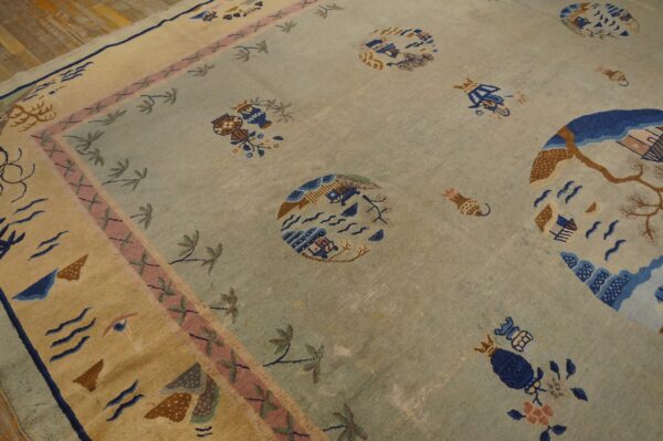Light blue rug features scattered scenic designs and a wide border with pink and tan accents on wood flooring.