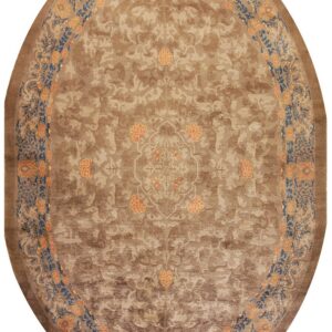 Oval tan rug with tone-on-tone scrolling patterns and a bright blue and orange floral border.