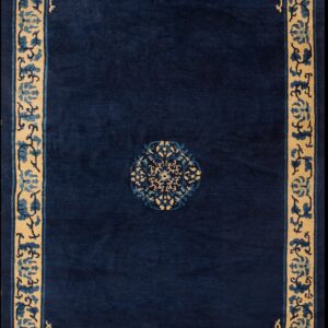 High-pile navy blue rug with a beige floral border and a small matching blue and tan center medallion.
