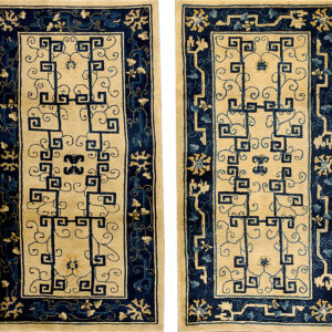 A pair of rectangular rugs featuring a cream field, navy blue fretwork, and stylized floral borders.