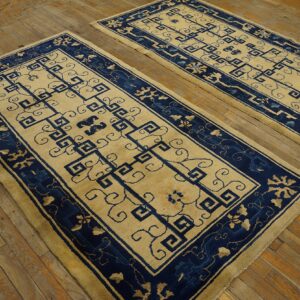 Matching pair of blue and beige patterned runner rugs with angular motifs displayed on rustic wood flooring.
