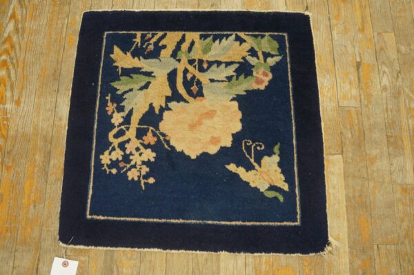 Antique peking square small scatter size wool black & navy rug 2 Navy blue square rug featuring a large floral design in pale yellow and green rests on rustic wood planks.
