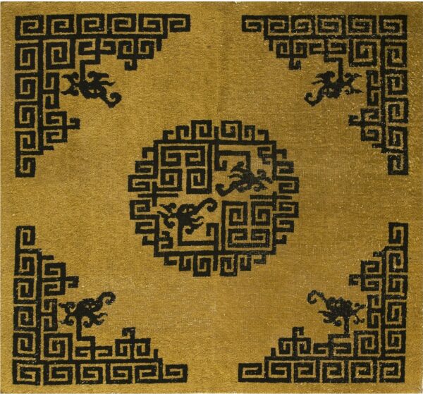Low-pile rug with a gold field and a black meander pattern forming a medallion and corner designs.