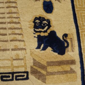 Beige rug detail featuring a dark blue stylized lion and brown architectural and geometric patterns.
