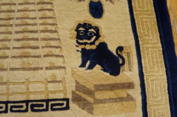 Beige rug detail featuring a dark blue stylized lion and brown architectural and geometric patterns.