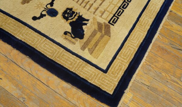 Close-up of a high-pile cream and navy rug with geometric patterns on aged wood flooring.