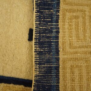 Tan rug detail contrasting shaggy high pile, dark blue lines, and geometric flatweave textures.
