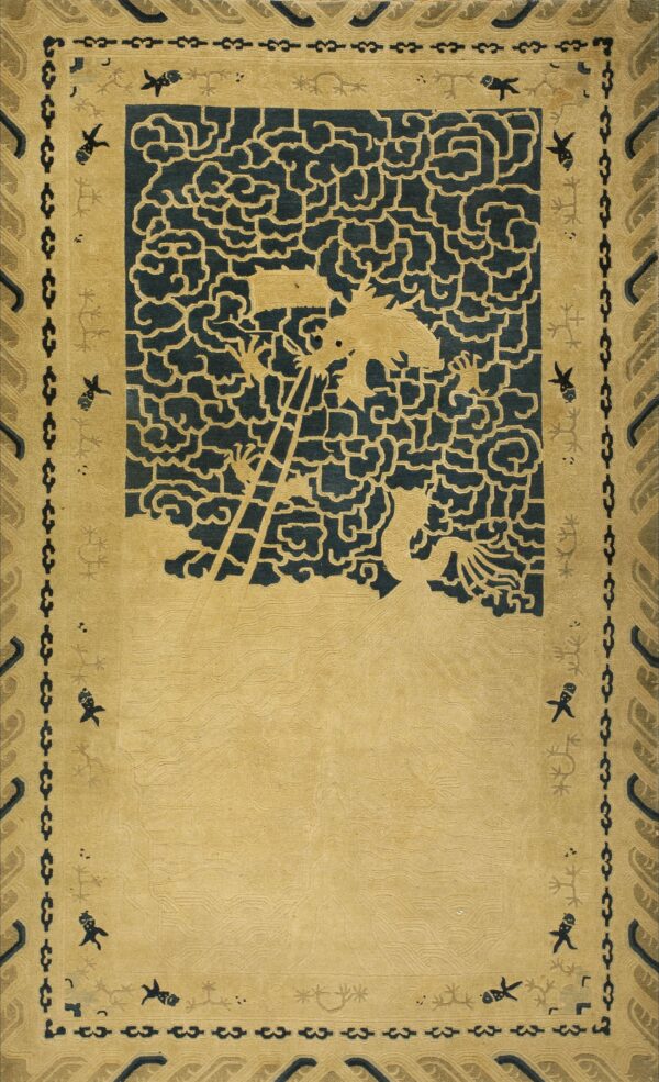 Tan and dark blue rug featuring a stylized dragon climbing out of cloud patterns above a textured field.