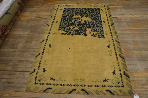 Sculpted yellow rug with navy blue cloud designs and figural borders rests on rustic wood flooring.