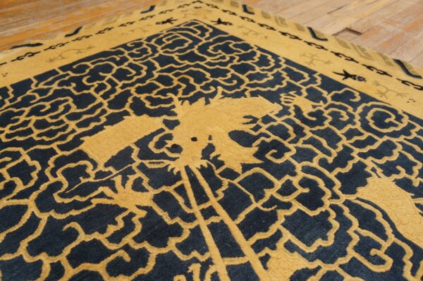 High-contrast navy and mustard rug with a detailed, stylized central design resting on hardwood planks.
