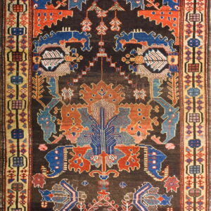 Dark brown low-pile rug with geometric and animal designs in vivid red, blue, and tan.