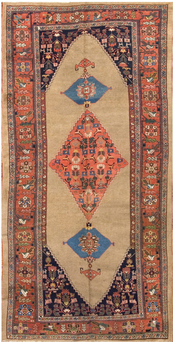 Tan rug with a rust and blue central geometric medallion framed by detailed red-orange borders.