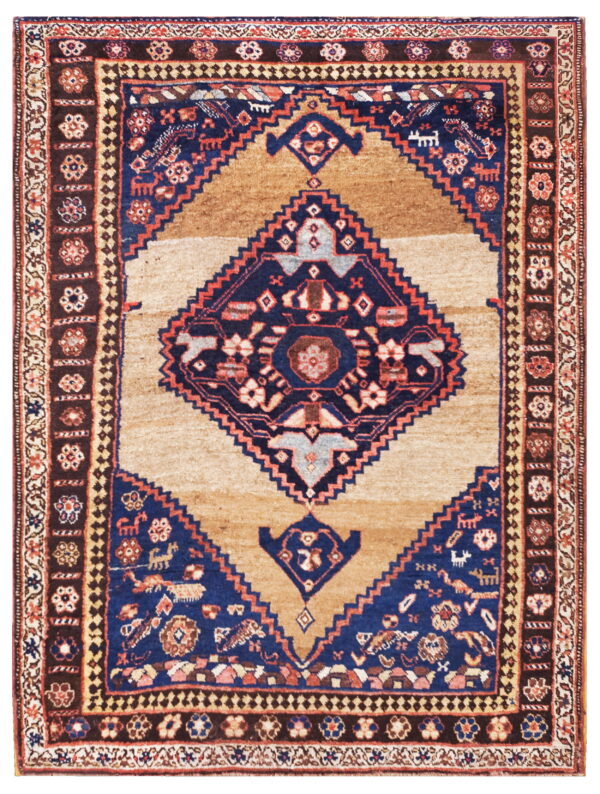 Tan rug with a large navy blue geometric medallion and multiple dark brown and blue borders.