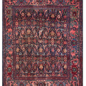 Traditional dark blue rug with intricate floral patterns and a striking wide salmon pink border.