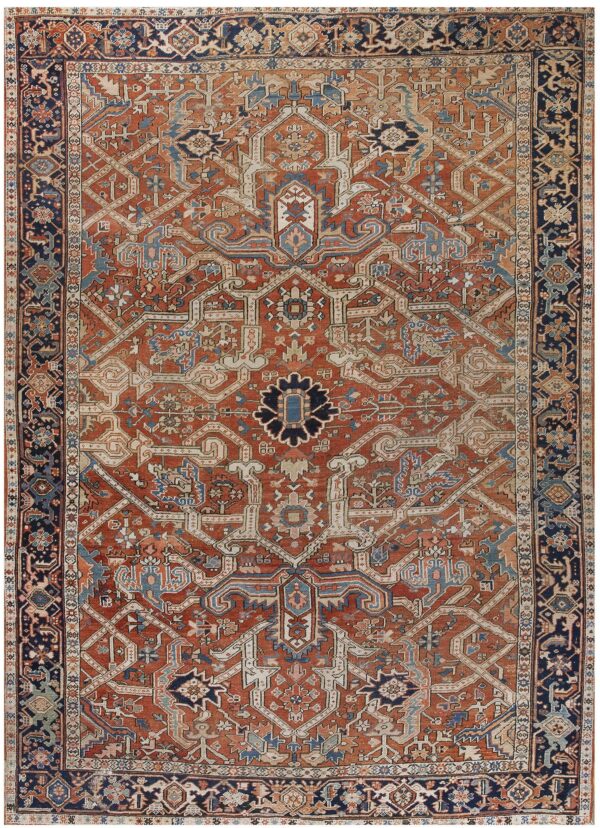 Geometric rug featuring an intricate rust and cream field design surrounded by a wide navy border.