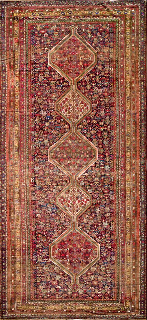 Dense red and navy runner rug with three interconnected geometric medallions and wide, detailed borders.