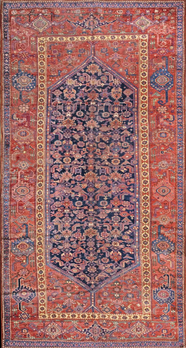 Upright shot of a detailed navy and terracotta geometric rug with a central diamond medallion design.