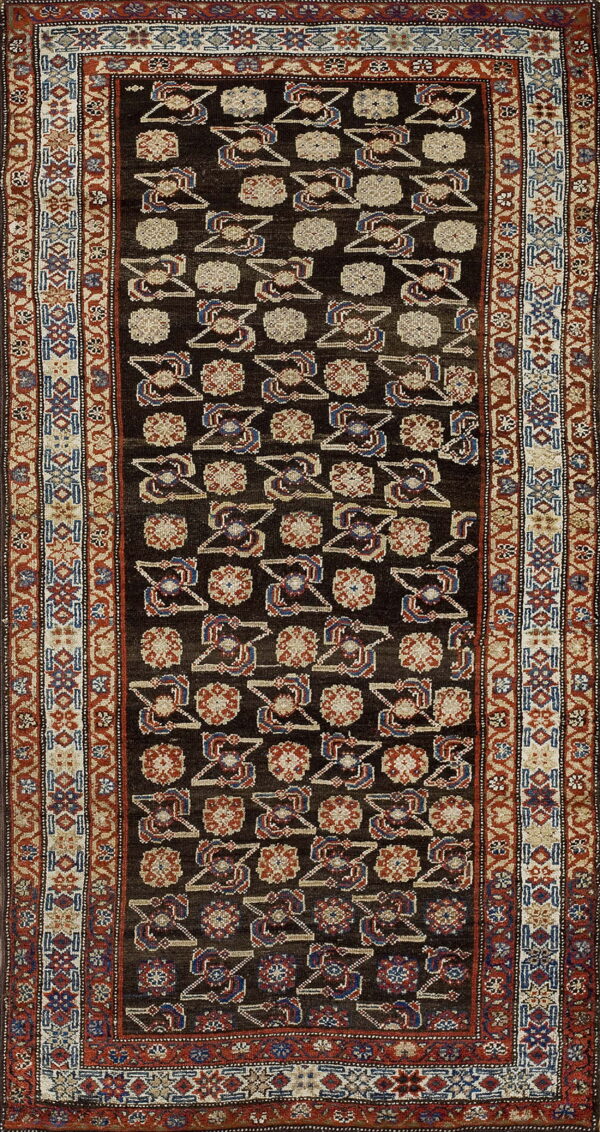Dark runner rug featuring geometric tribal patterns in red, blue, and beige on a dark brown field.