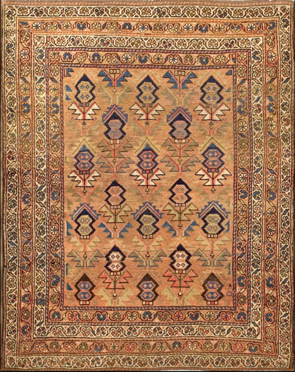 Peach-tan geometric rug featuring stylized navy, blue, and green diamond patterns inside a detailed floral border.