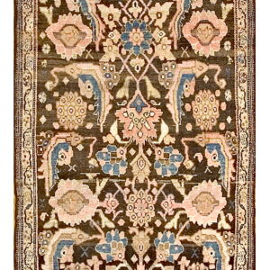 A detailed rug with a dark brown field patterned with pink, cream, and muted blue traditional floral motifs.