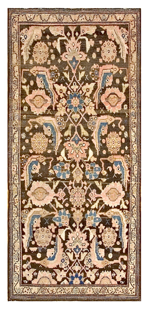 A detailed rug with a dark brown field patterned with pink, cream, and muted blue traditional floral motifs.