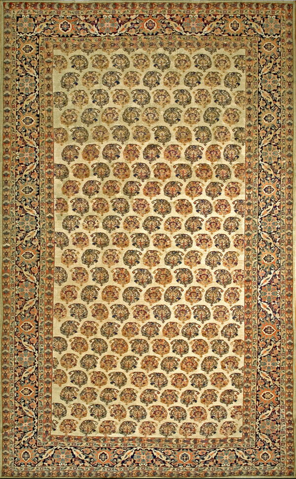 A detailed traditional rug with an ivory field featuring rows of rust and blue repeating floral medallions and complex dark borders.