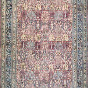 Red and cream rug with repeating stylized tree patterns and a dark blue floral border.