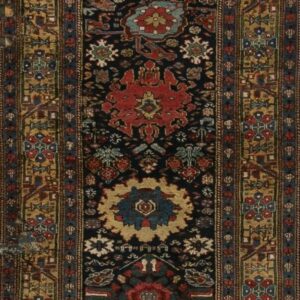 Long runner rug with a navy background, traditional red and gold geometric motifs, and ornate tan and blue triple borders.