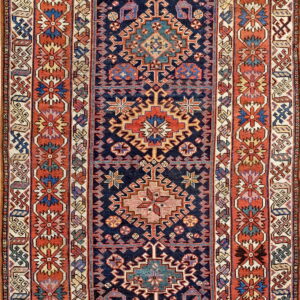 Low-pile rug featuring a dark blue central field with geometric medallions and wide terracotta borders.