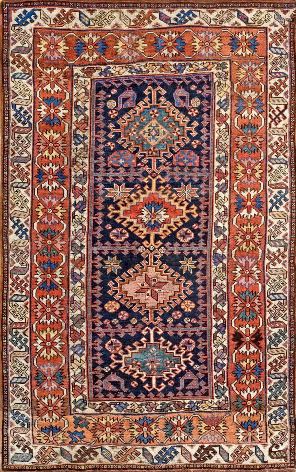 Low-pile rug featuring a dark blue central field with geometric medallions and wide terracotta borders.