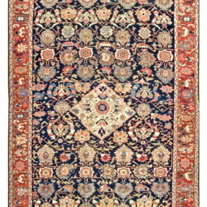 Navy blue runner rug with dense botanical patterns, a central cream medallion, and a wide rust colored border.