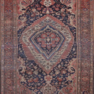 Navy and faded red traditional rug featuring a large central medallion and dense floral motifs.
