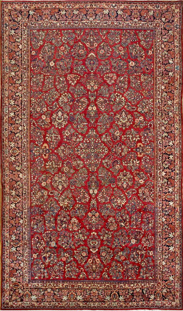 Rectangular rug with an intricate all-over floral pattern in red, navy, cream, and varied accents.