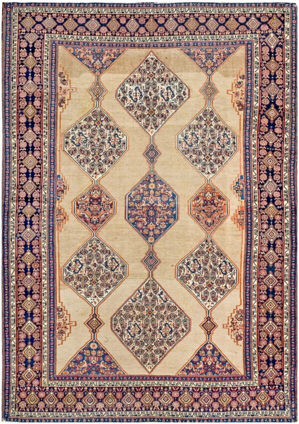 Tan rug with linked diamond medallions and ornate borders in deep blue, rust, and cream colors.