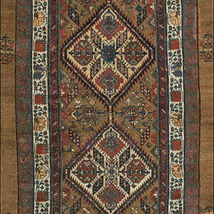 A long runner rug features a central column of diamond medallions with complex geometric patterns in red, blue, and cream on a tan field.